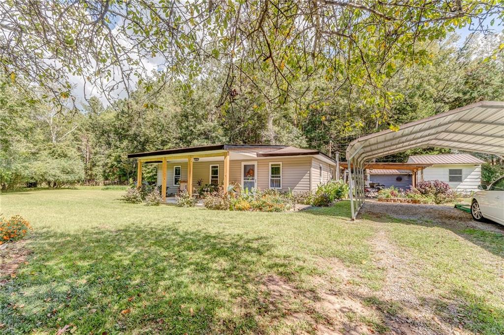 1525 Sloppy Floyd Lake Road Summerville, GA 30747 - Photo 2 of 16 a front view of a house with a garden and trees