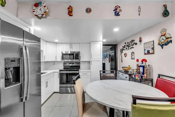 a kitchen with stainless steel appliances a stove a refrigerator and a dining table