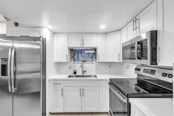 a kitchen with stainless steel appliances a refrigerator sink and stove