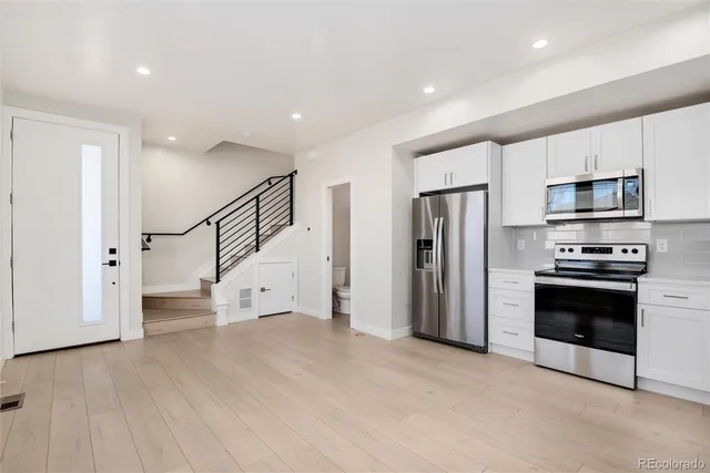 a view of kitchen with stainless steel appliances kitchen island wooden floor and window