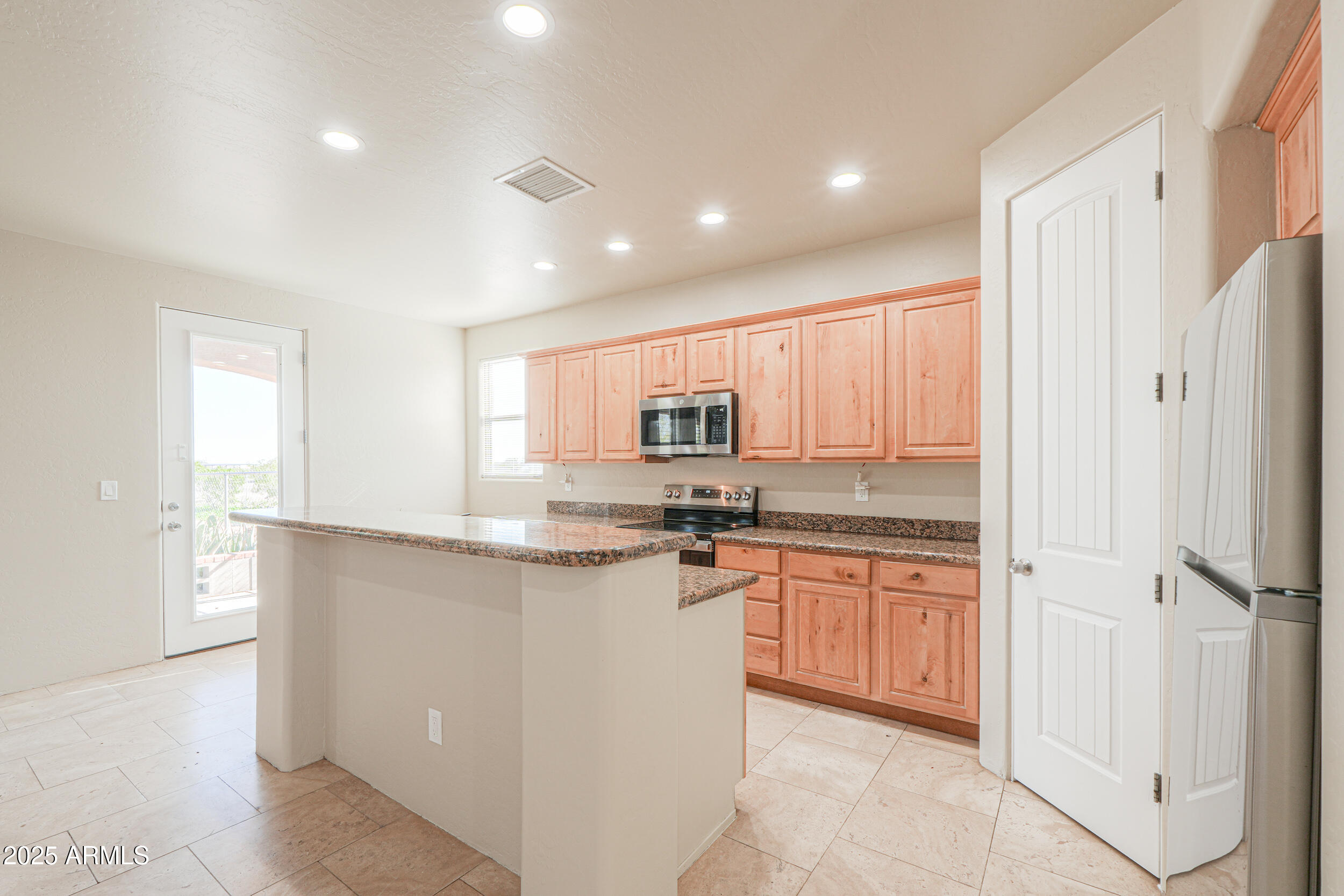 53304 West Barnes Road Maricopa, AZ 85139 - Photo 13 of 75 a kitchen with stainless steel appliances granite countertop a stove a sink and a refrigerator