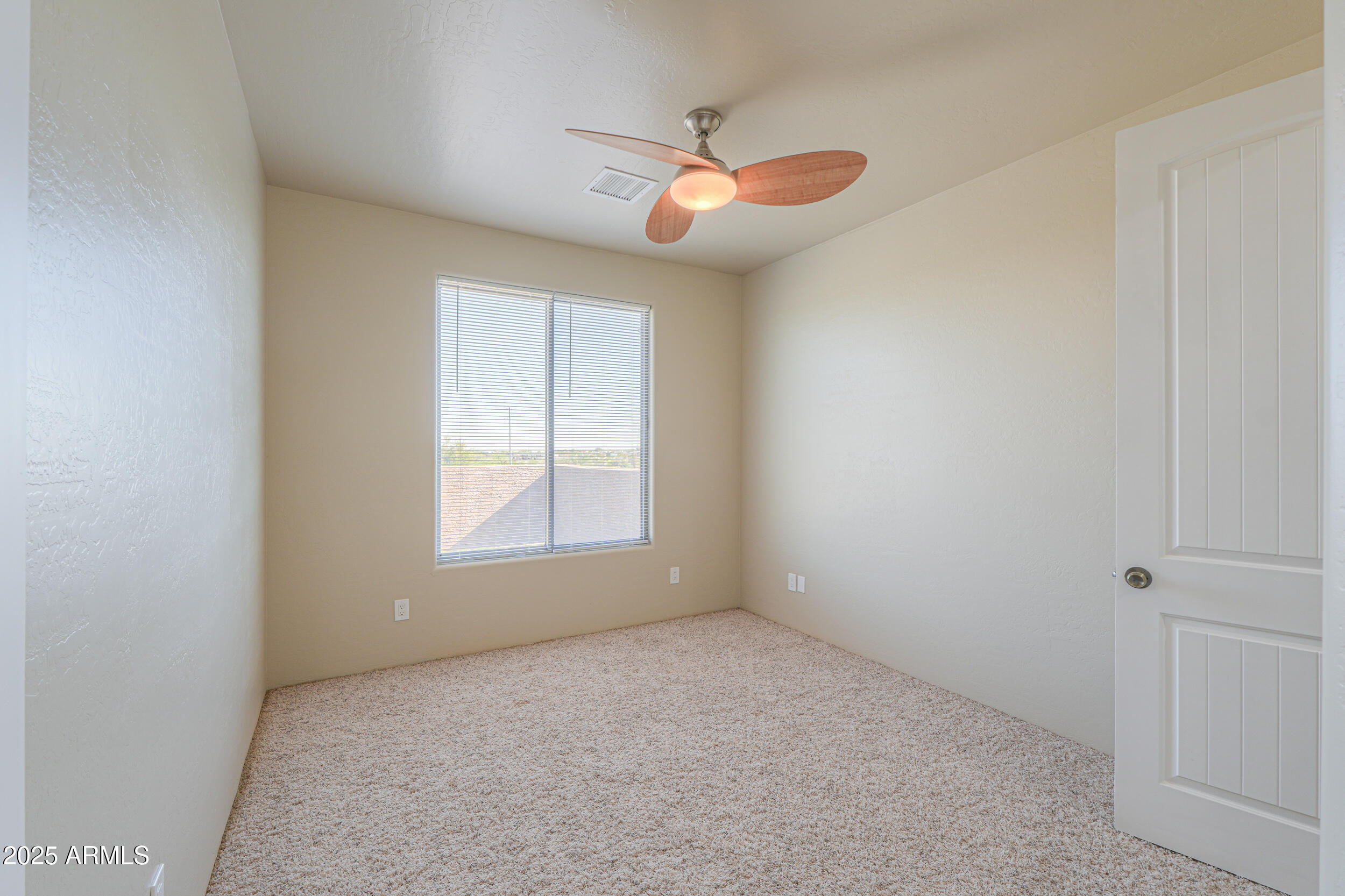 53304 West Barnes Road Maricopa, AZ 85139 - Photo 25 of 75 an empty room with a chandelier fan and windows