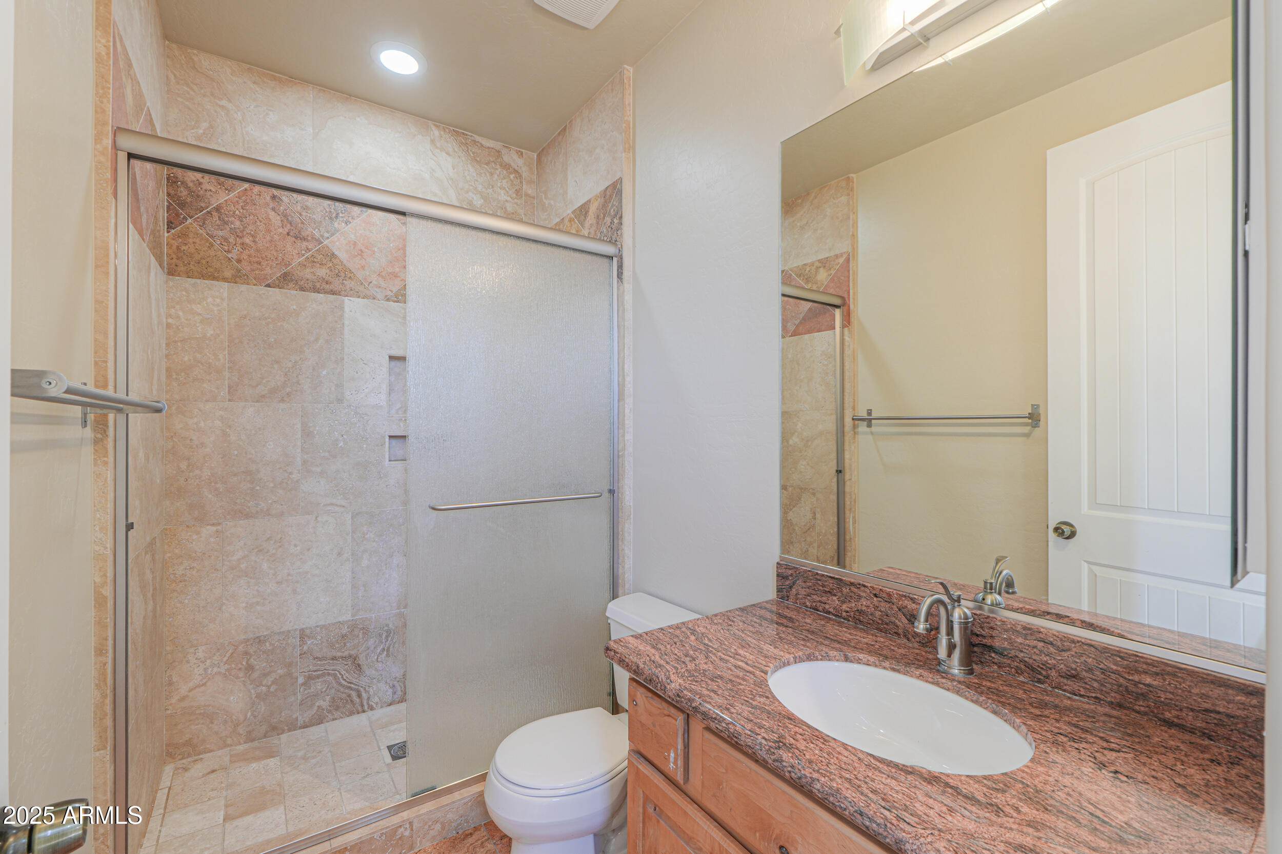 53304 West Barnes Road Maricopa, AZ 85139 - Photo 28 of 75 a bathroom with a granite countertop sink toilet a mirror and shower