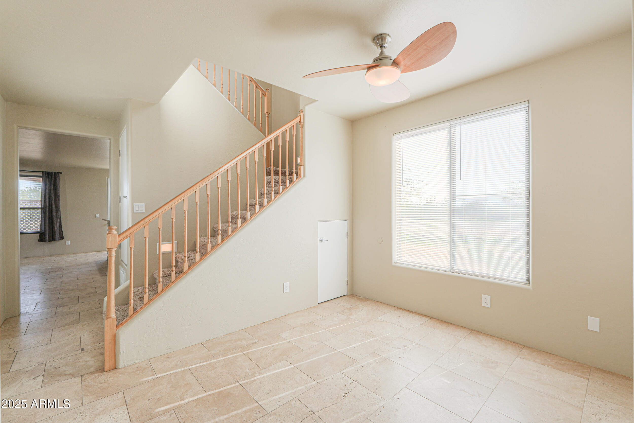 53304 West Barnes Road Maricopa, AZ 85139 - Photo 8 of 75 a view of an empty room with wooden floor and a ceiling fan