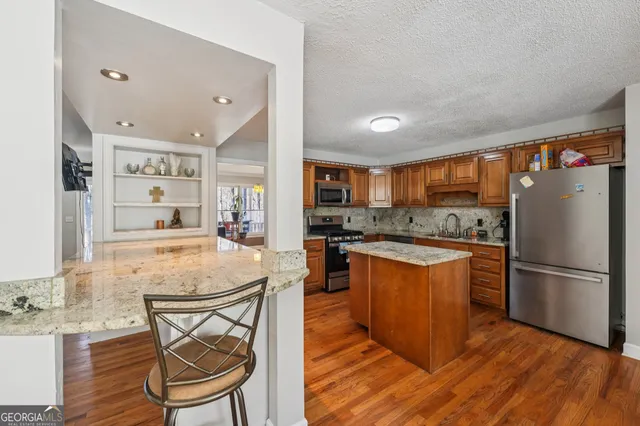 a large kitchen with stainless steel appliances granite countertop a large counter top and sink