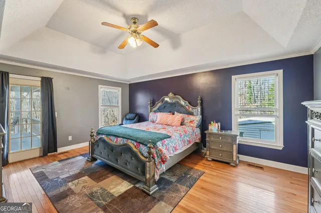 a bedroom with a bed and a flat tv screen on dresser