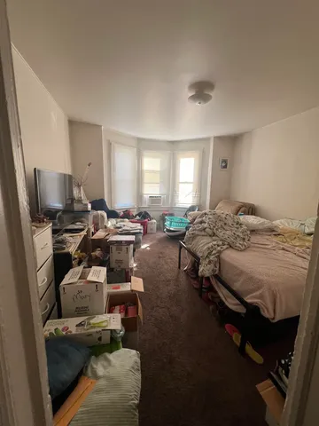 a bedroom with bed and a flat screen tv