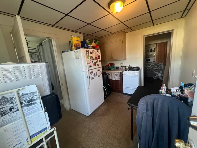 a view of a kitchen with fridge and wooden floor