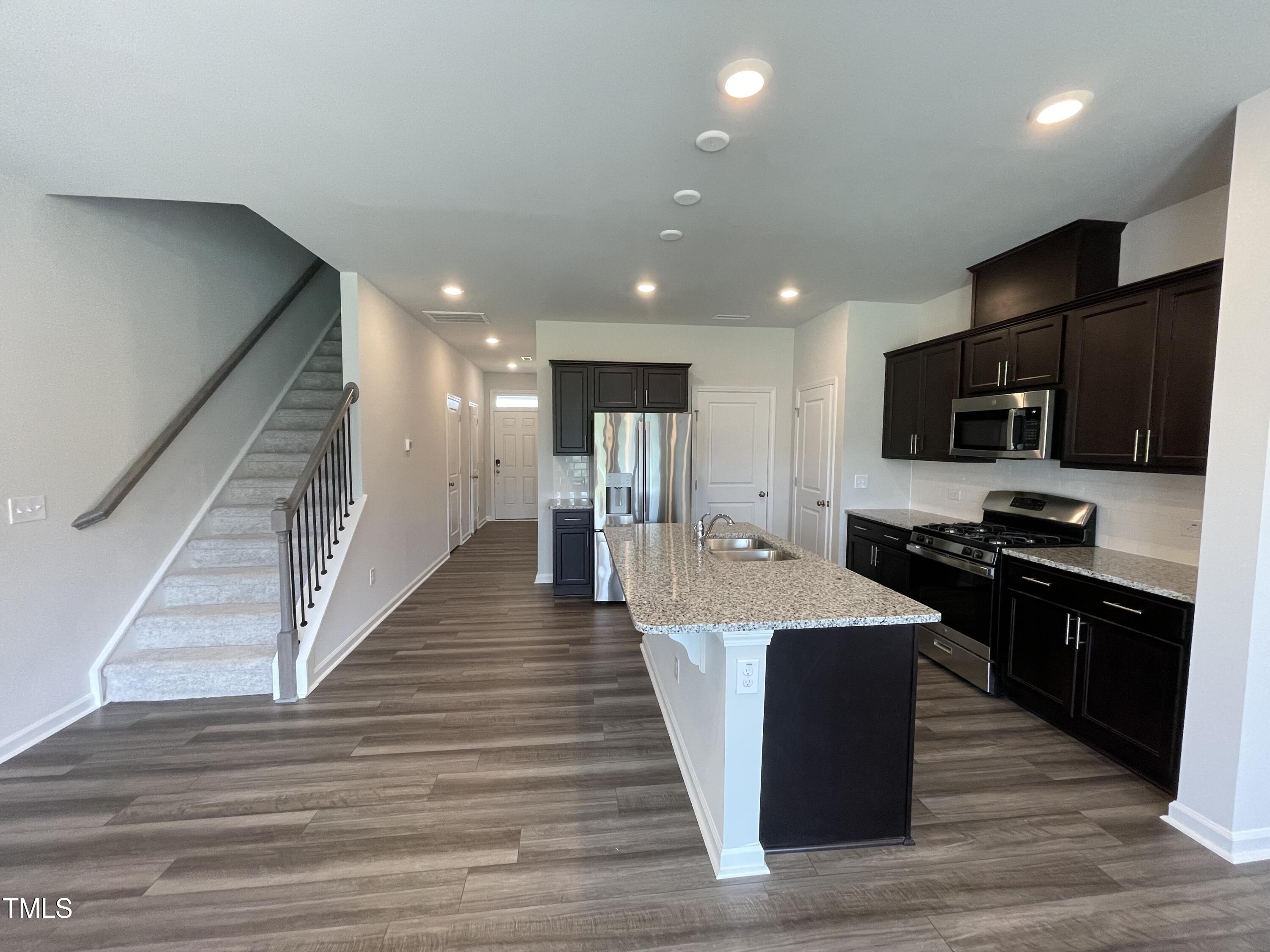 244 Paramount Drive Smithfield, NC 27577 - Photo 4 of 43 a large kitchen with stainless steel appliances kitchen island granite countertop a stove and a wooden floors