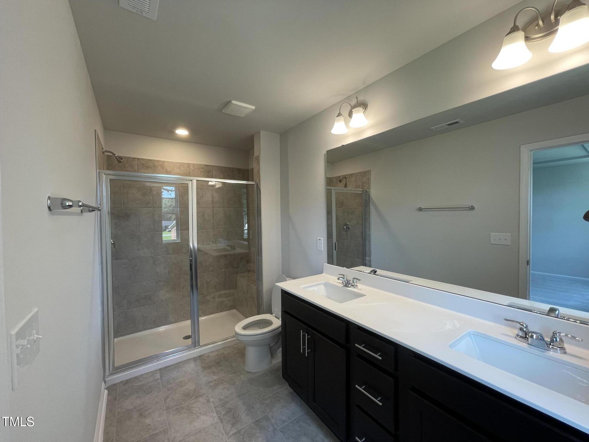 244 Paramount Drive Smithfield, NC 27577 - Photo 10 of 43 a bathroom with a double vanity sink mirror and shower