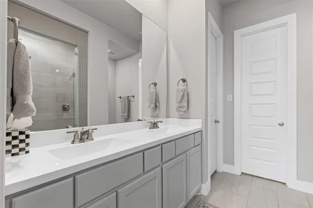 a bathroom with a granite countertop shower sink and mirror