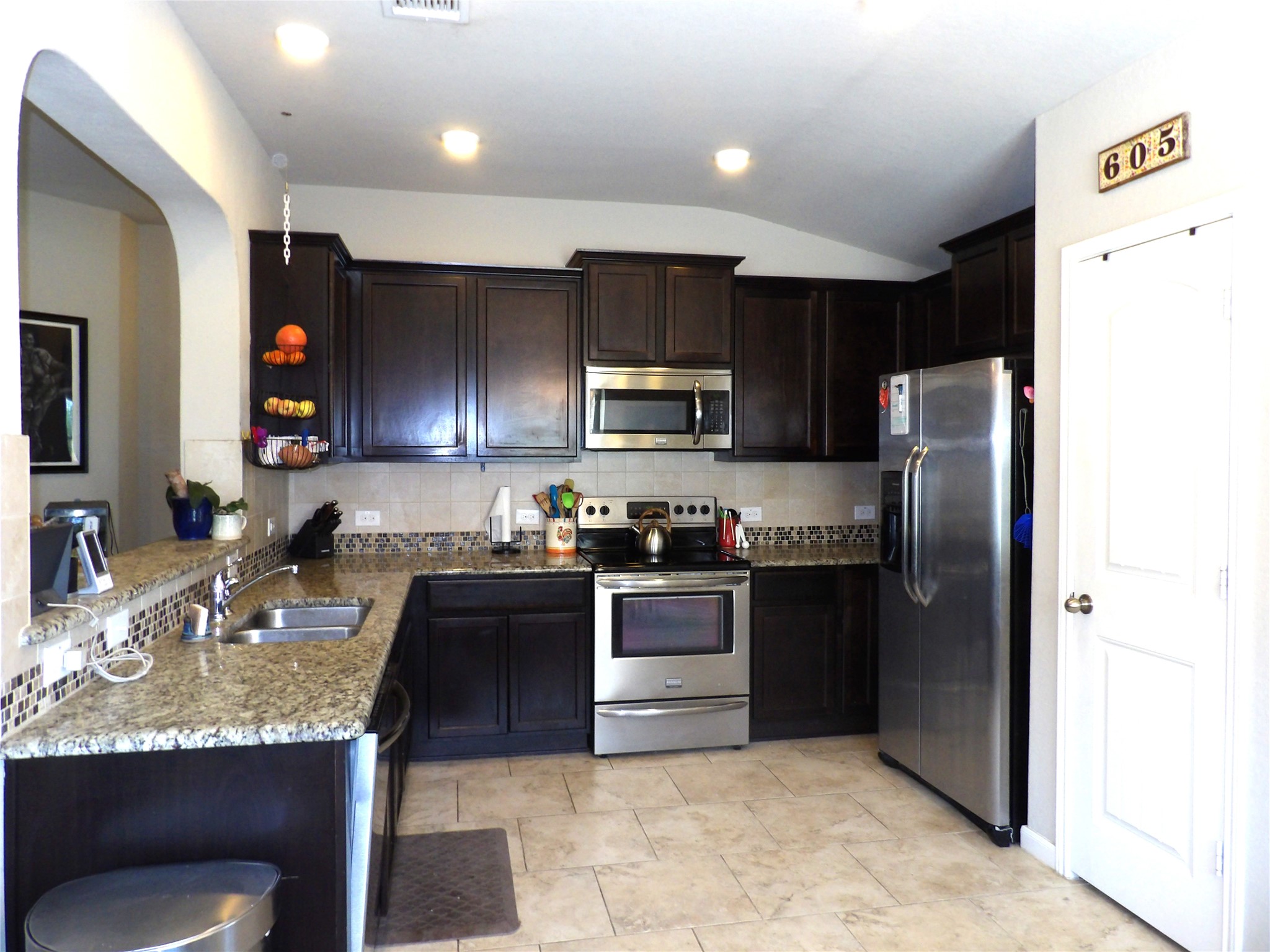 930 Pumpkin Ridge New Braunfels, TX 78130 - Photo 6 of 32 Kitchen featuring dark wood cabinetry, light granite countertops, a stainless steel appliance suite, tile flooring, and recessed lighting