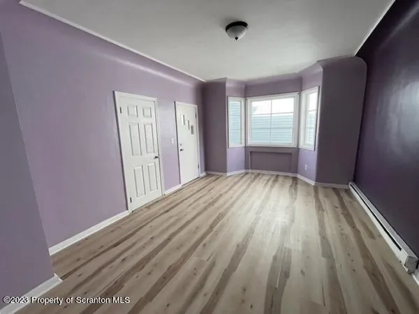 a view of a livingroom with wooden floor and window