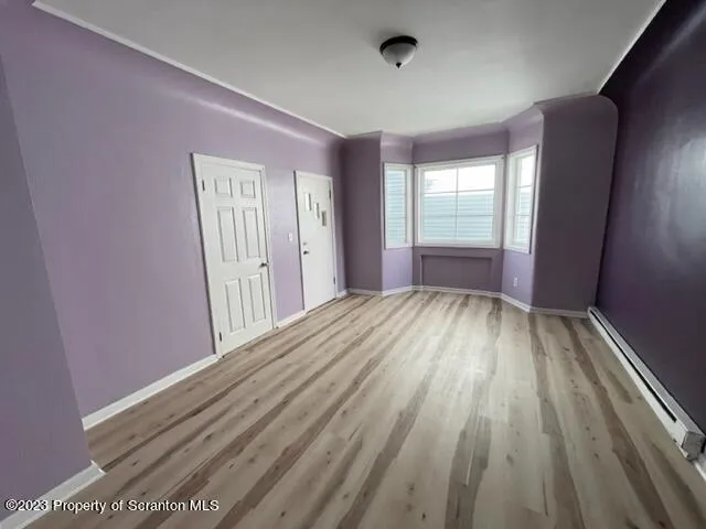 a view of a livingroom with wooden floor and window