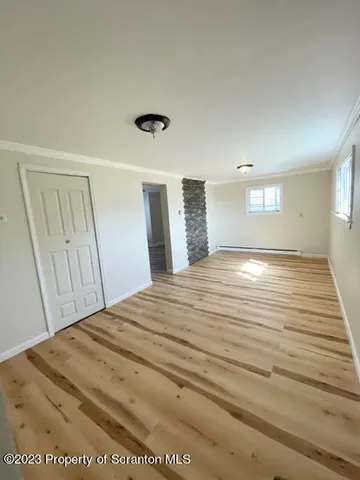 a view of empty room with window and wooden floor