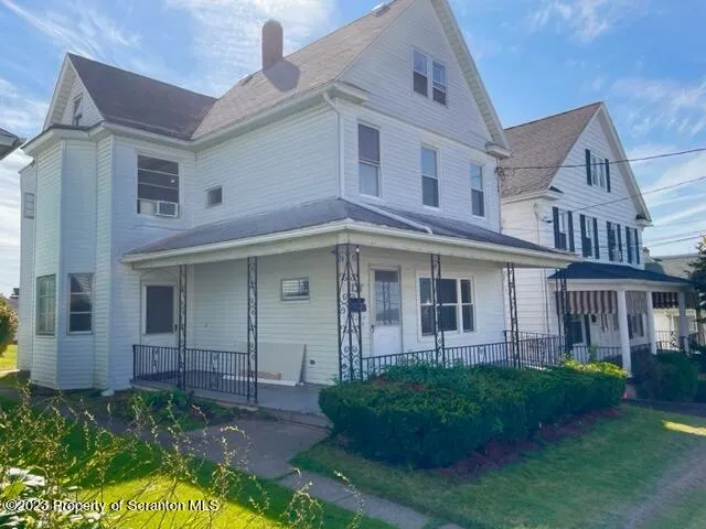 a view of a white house next to a yard