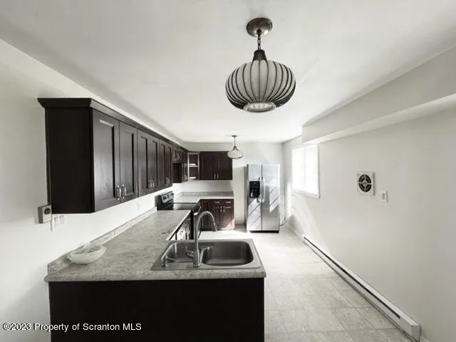 a kitchen with a sink a counter space and a refrigerator