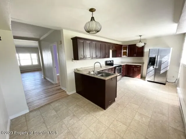 a kitchen with stainless steel appliances granite countertop a stove a sink and a refrigerator