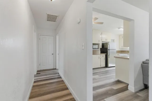 a view of a hallway with wooden floor and staircase