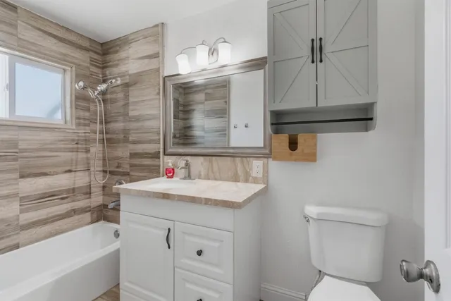 a bathroom with a sink a toilet and shower