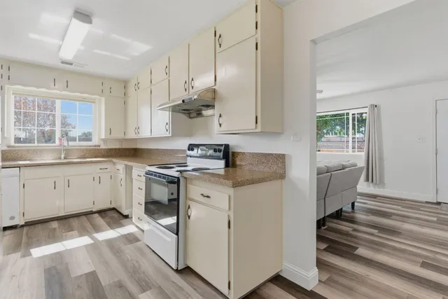 a kitchen with cabinets appliances and a window