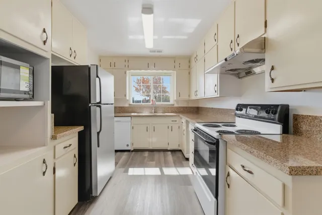 a kitchen with a stove a sink and a refrigerator