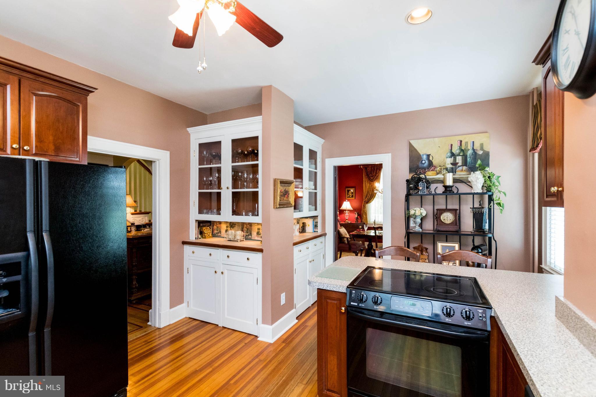 423 South Rolling Road Baltimore, MD 21228 - Photo 11 of 30 a kitchen with stainless steel appliances granite countertop a refrigerator a stove and a sink with wooden floor