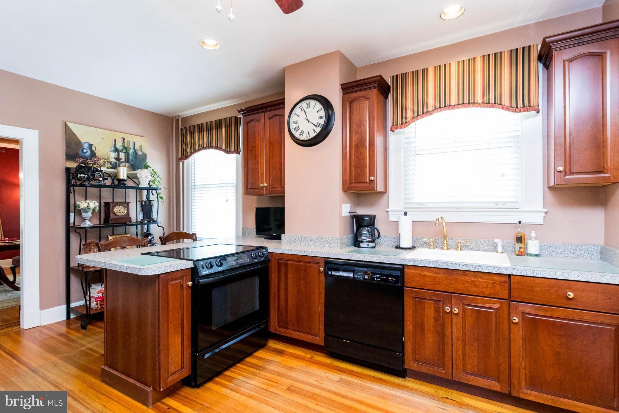 423 South Rolling Road Baltimore, MD 21228 - Photo 12 of 30 a kitchen with stainless steel appliances granite countertop a sink a stove and a wooden cabinets
