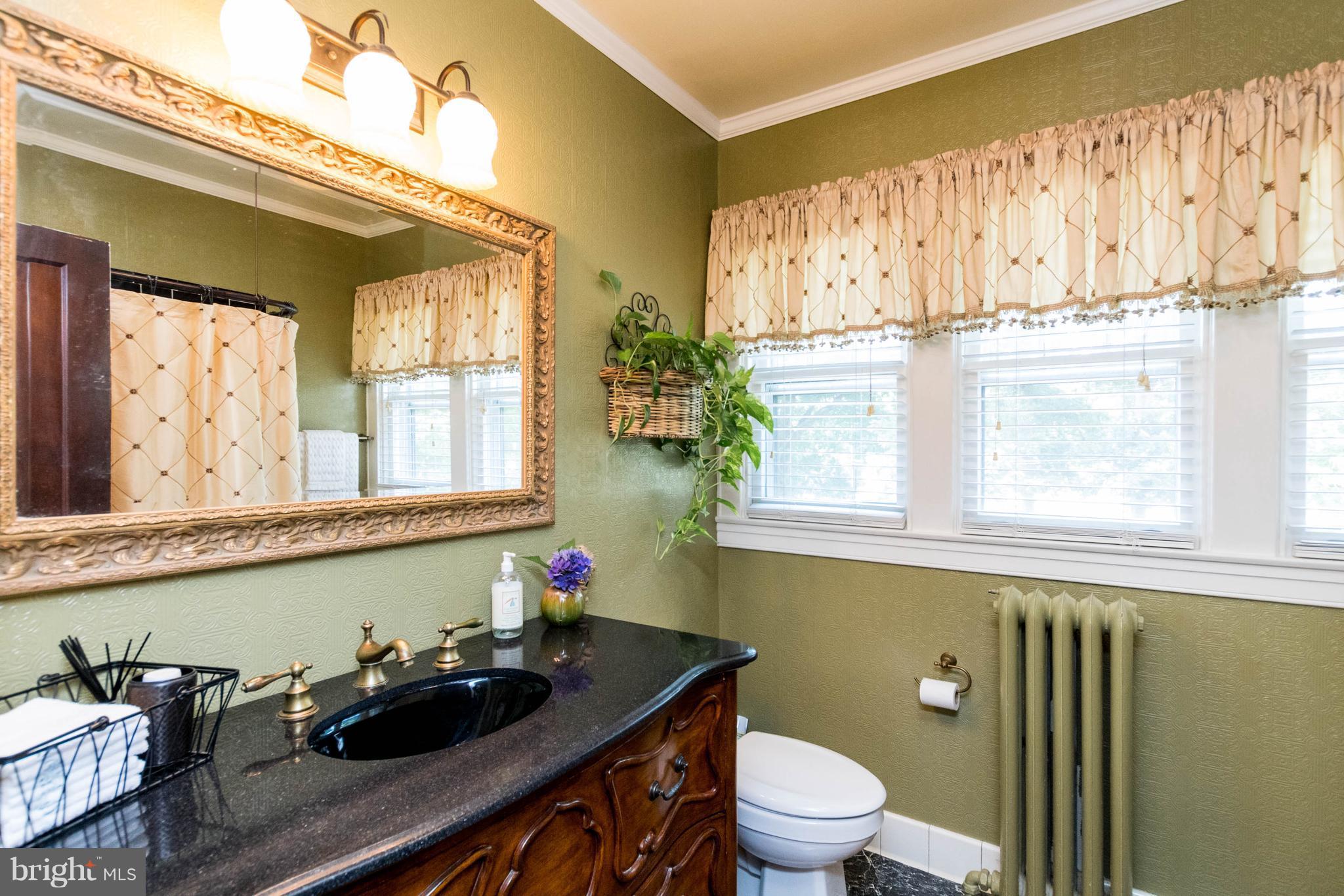423 South Rolling Road Baltimore, MD 21228 - Photo 23 of 30 a bathroom with a granite countertop sink and a toilet