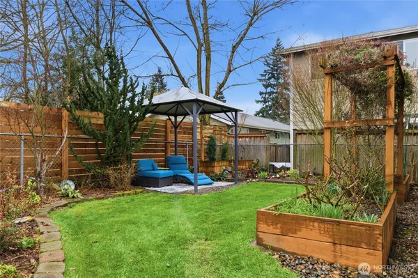a view of a backyard with table and chairs under an umbrella