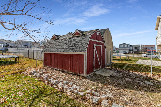 4239 West 5325th Street South Roy, UT 84067 - Photo 22 of 26 View of shed with a fenced backyard, a residential view, and a trampoline