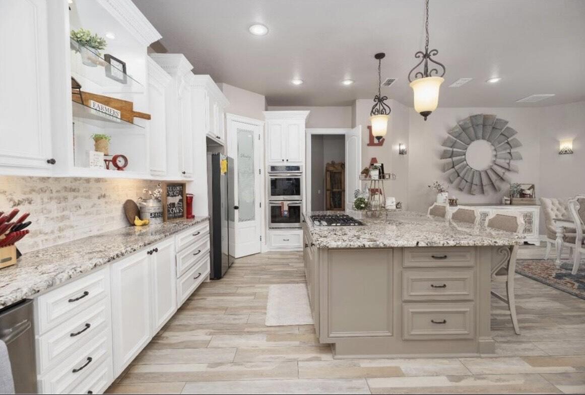8 West Lakeshore Drive Ransom Canyon, TX 79366 - Photo 17 of 44 a kitchen with stainless steel appliances granite countertop a sink and a stove