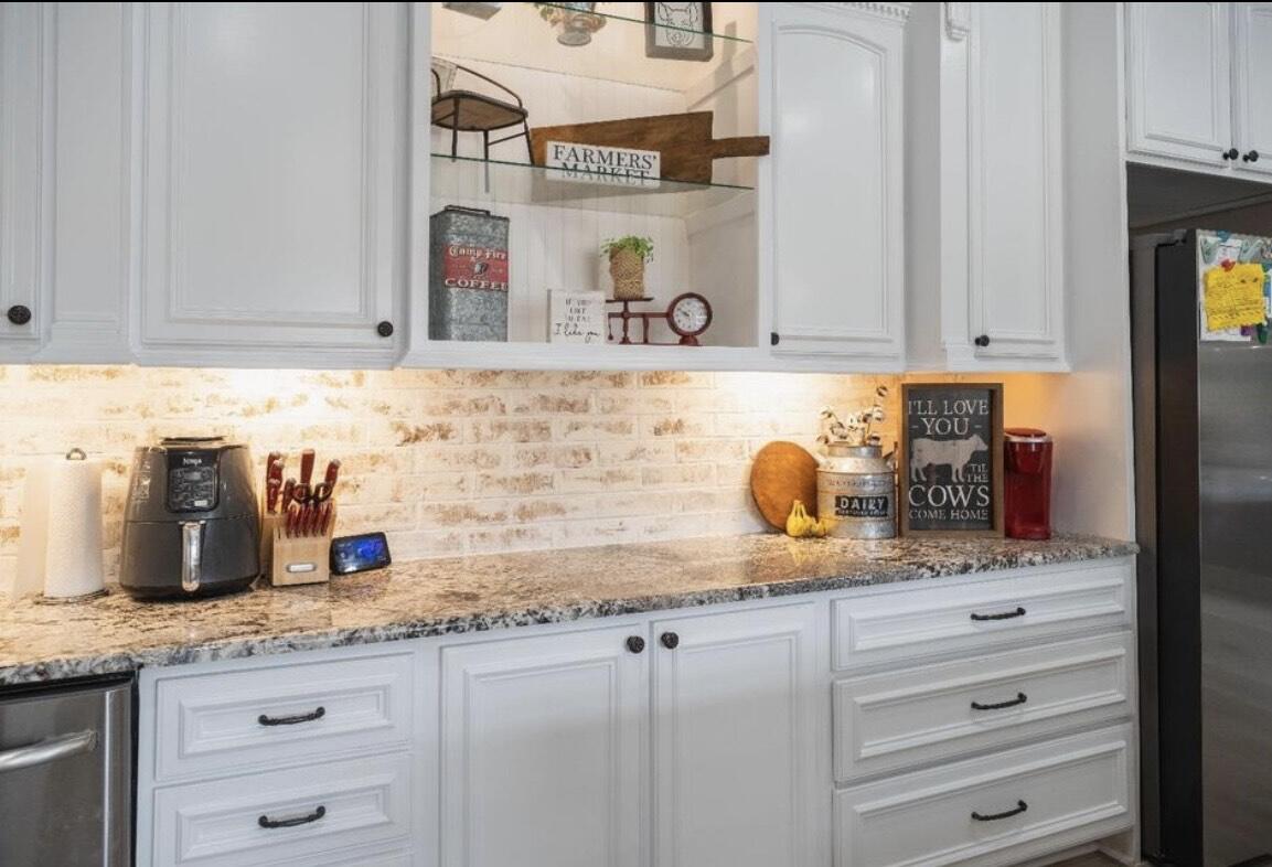 8 West Lakeshore Drive Ransom Canyon, TX 79366 - Photo 18 of 44 a kitchen with granite countertop a sink and cabinets