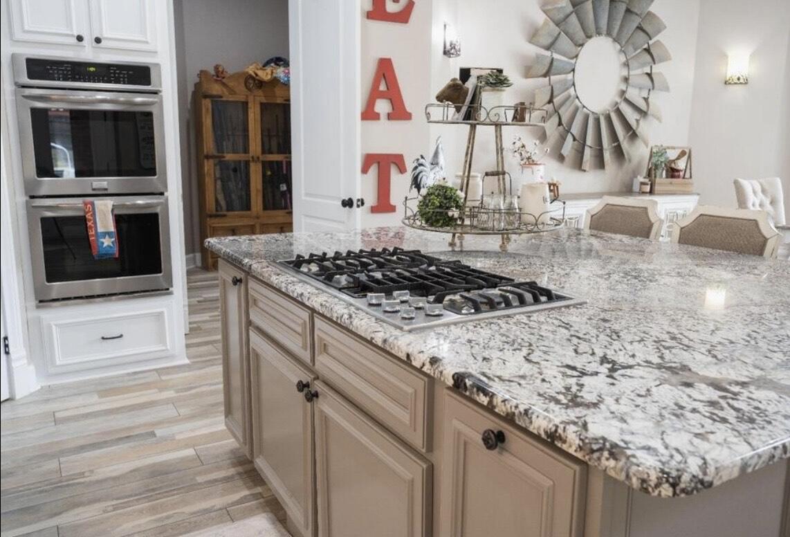 8 West Lakeshore Drive Ransom Canyon, TX 79366 - Photo 20 of 44 a kitchen with granite countertop a stove and a microwave