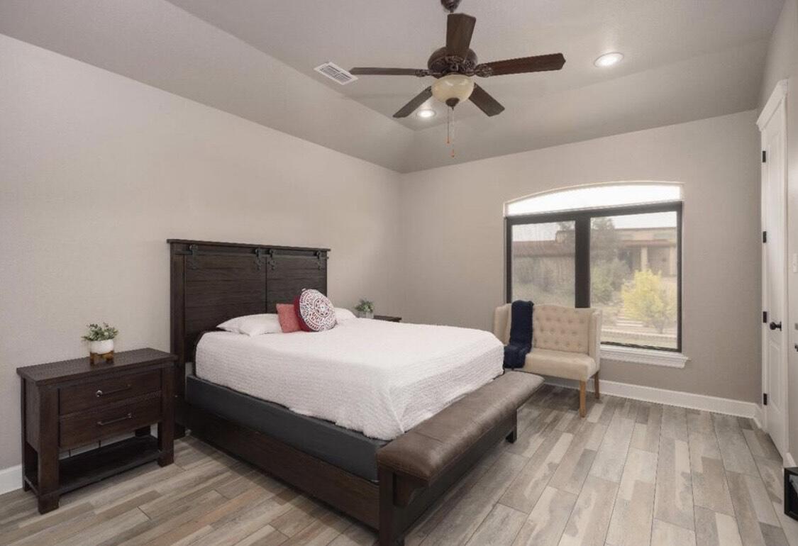 8 West Lakeshore Drive Ransom Canyon, TX 79366 - Photo 24 of 44 a bedroom with a bed and wooden floor
