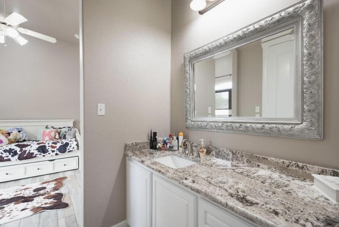 8 West Lakeshore Drive Ransom Canyon, TX 79366 - Photo 32 of 44 a bathroom with a granite countertop sink and a mirror