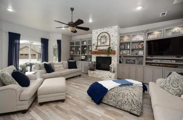 a living room with furniture a flat screen tv and a fireplace