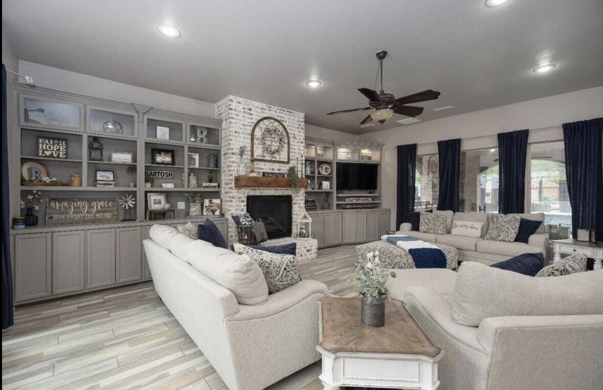 8 West Lakeshore Drive Ransom Canyon, TX 79366 - Photo 9 of 44 a living room with furniture a fireplace and a chandelier