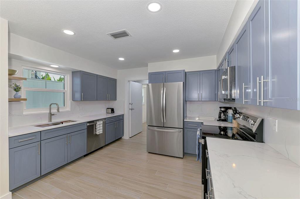 1100 Point Of Rocks Road Sarasota, FL 34242 - Photo 11 of 53 a kitchen with a refrigerator sink and wooden cabinets