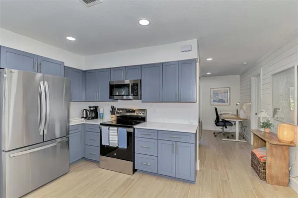 a kitchen with stainless steel appliances a refrigerator and wooden cabinets