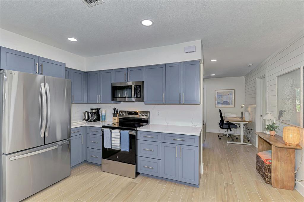 1100 Point Of Rocks Road Sarasota, FL 34242 - Photo 12 of 53 a kitchen with stainless steel appliances a refrigerator and wooden cabinets