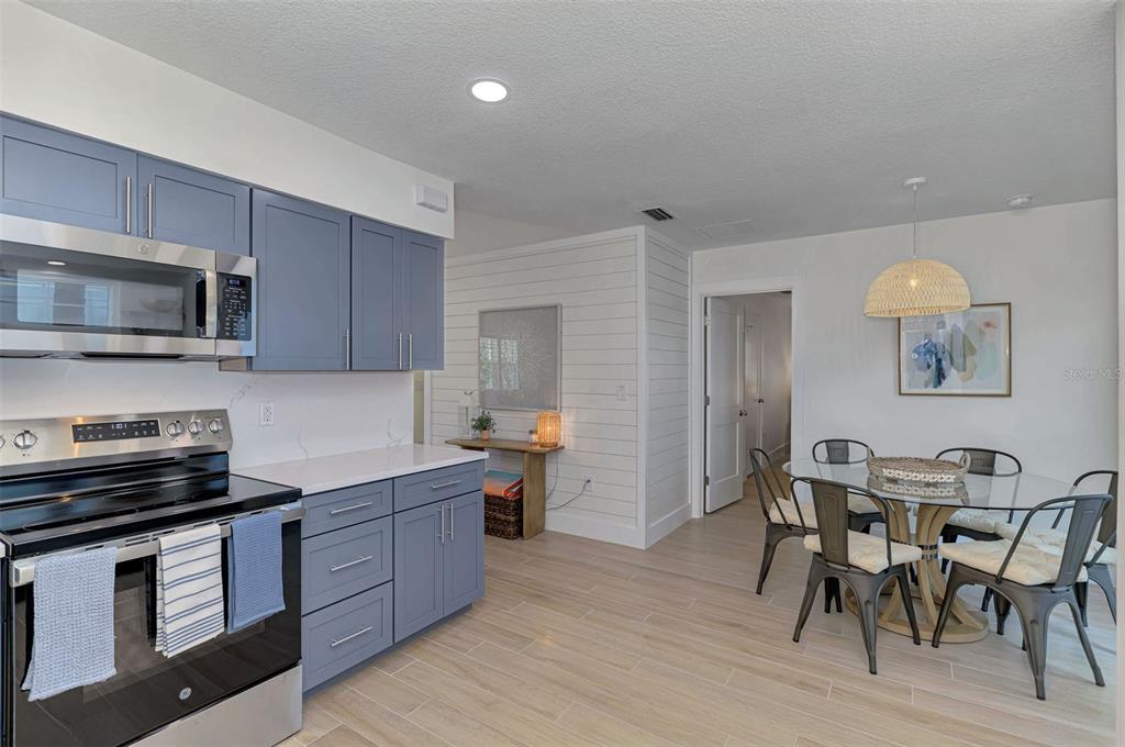 1100 Point Of Rocks Road Sarasota, FL 34242 - Photo 13 of 53 a kitchen with stainless steel appliances a stove a sink a microwave a refrigerator and chairs