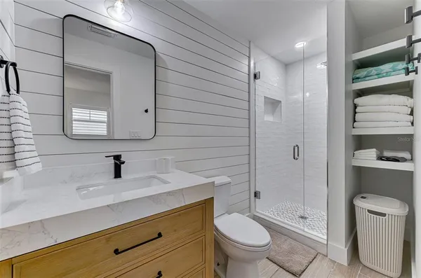 a bathroom with a sink a toilet and shower