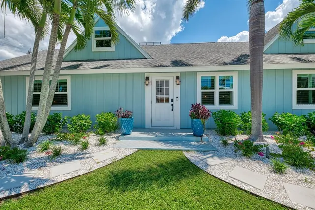 a front view of a house with a yard and potted plants