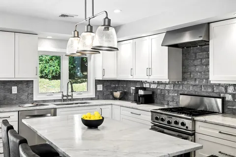 a kitchen with a stove a sink and a chandelier