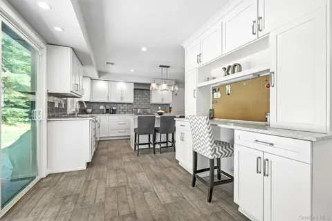 a living room with stainless steel appliances granite countertop furniture wooden floor and kitchen view