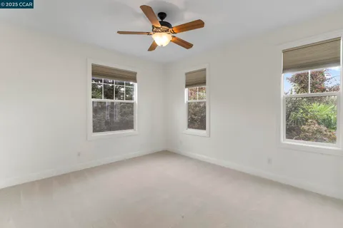an empty room with a window and a fan