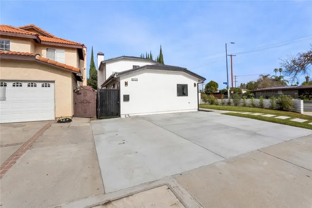 a view of a house with a yard and potted plants