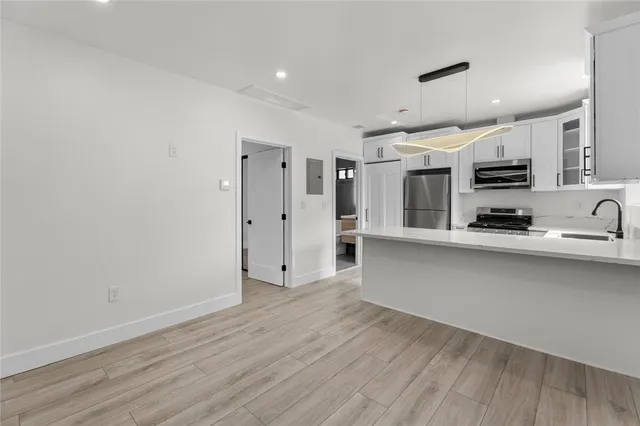 a view of kitchen with stainless steel appliances a refrigerator and a microwave