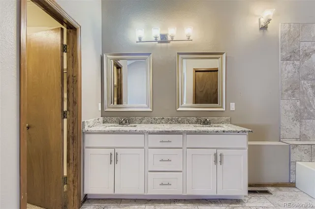a bathroom with a granite countertop sink and a mirror